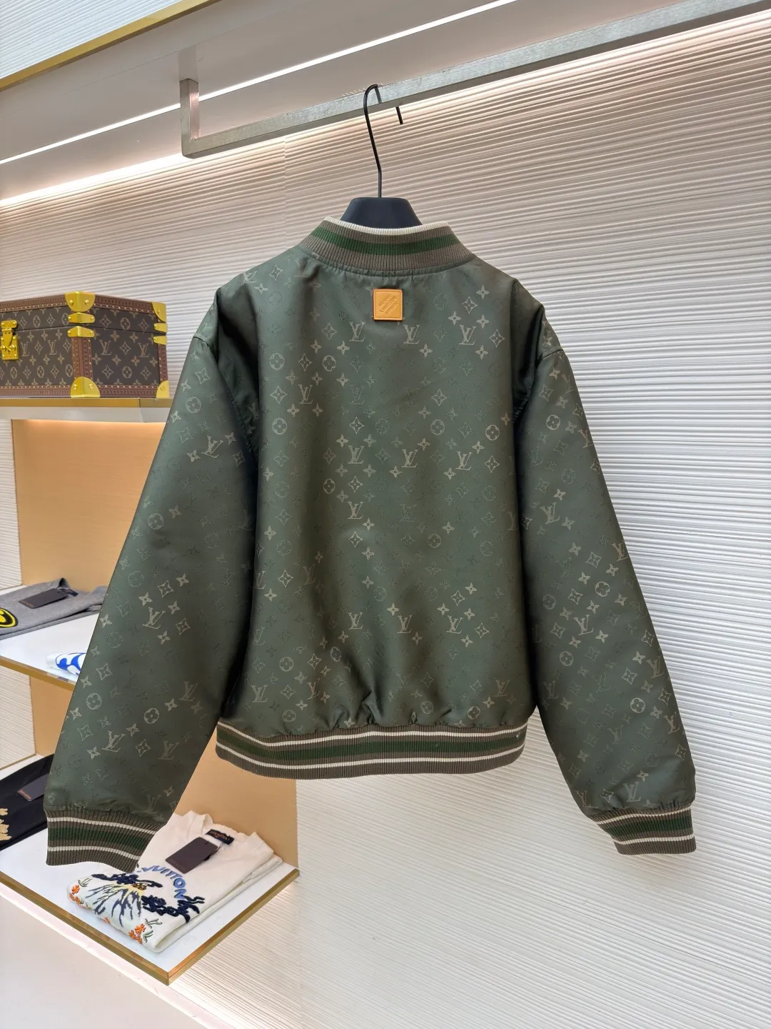 LOUIS VUITTON striped trim jacquard long-sleeved bomber jacket ●Original version: purchased and developed by 29237 ●Item number: 1682087-C05 ●Fabric: nylon fabric ●Technology: jacquard production ●Color: green ●Version: fitted version ●Weight: about 800 grams ●Size: S-M-L-XL ●Description: This Louis Vuitton baseball jacket is made of high-density jacquard satin fabric. The base is a polyester fiber blended material with a military green matte texture. The classic Monogram presbyopia pattern is woven into the fabric in the form of dark patterns of the same color through a special weaving process. The pattern texture is three-dimensional and presents a delicate illusion luster with the angle of light. High-precision jacquard weaving technology is used in the process to ensure the integrity and delicacy of the pattern. The body adopts a single-row metal snap closure design. The metal buckles are matte and distressed to echo the color of the body. The ribbed collar, cuffs and hem are made of two-color knitting technology. The elastic ribs have both stiffness and comfort, and are pre-shrunk to prevent deformation. The overall cut is a loose oversize version, and the splicing uses a combination of flat seams and hemming techniques. The interior is supplemented by smooth overlock sewing. Every stitch is even and fine, which fully reflects the brand's exquisite garment production technology and detail control. The overall wiring is straight and delicate, the fabric is comfortable and soft, and the color is consistent without color difference. It can be matched with the same style to create a fashionable look and control various occasions. Customized accessories, complete with three standards, same style for men and women!
